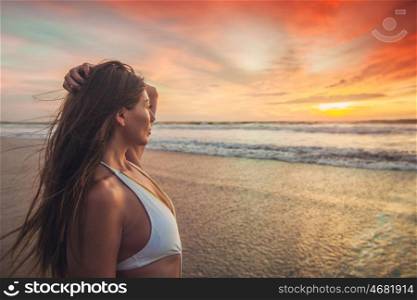 Woman in bikini at sunset. Beautiful sexy woman in bikini posing on beach at sunset