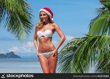 Woman in bikini celebrating Christmas. Woman in bikini celebrating Christmas on tropical beach with palms