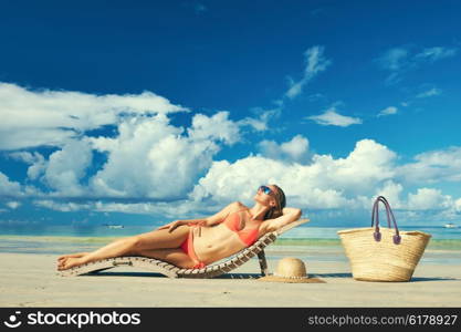 Woman in bikini lying on tropical beach at Seychelles