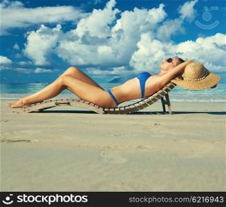 Woman in bikini lying on tropical beach at Seychelles
