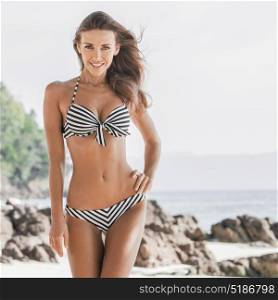 Woman in bikini on beach. Beautiful woman with perfect body in bikini posing on tropical beach