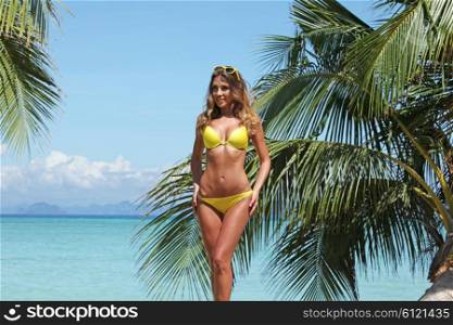 Woman in bikini on beach . Woman in bikini on a tropical beach with palm trees