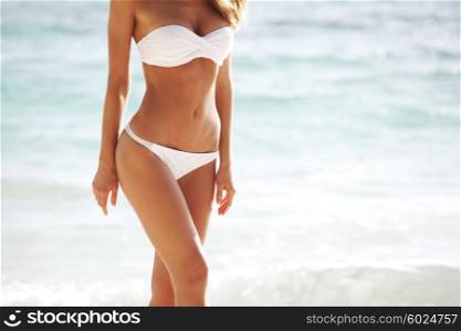 Woman in bikini on sea background. Woman with perfect body in bikini on sea background