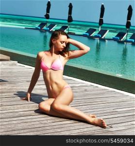 Woman in bikini relaxing at the poolside