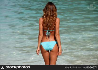 Woman in bikini. Woman with perfect body in bikini over blue sea background