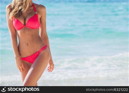 Woman in bikini. Woman with perfect body in bikini over blue sea background