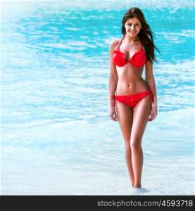 Woman in bikini. Woman with perfect body in red bikini over blue sea background