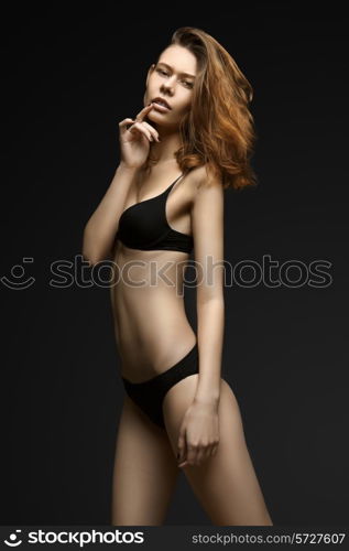 Woman in black underwear on black background