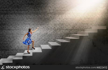 Woman in blindfold. Young woman in blue dress walking on ladder