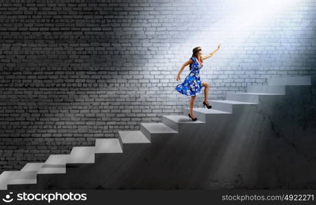 Woman in blindfold. Young woman in blue dress walking on ladder