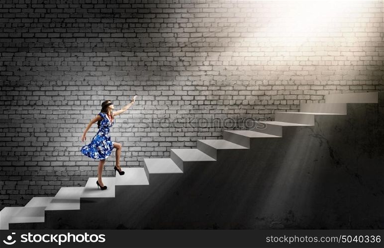 Woman in blindfold. Young woman in blue dress walking on ladder