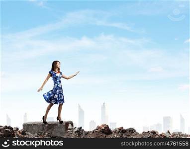 Woman in blue dress. Young woman in blue dress walking among city ruins