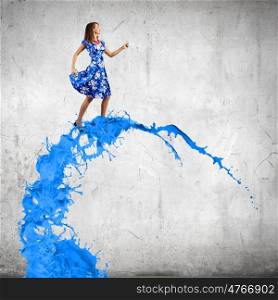 Woman in blue dress. Young woman in blue dress walking on colorful splashes