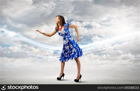 Woman in blue dress. Young woman in blue dress walking on roof of building