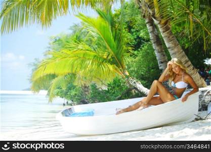 woman in boat under palm on sea background