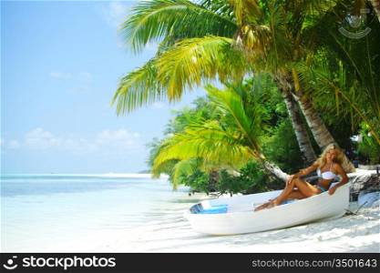 woman in boat under palm on sea background