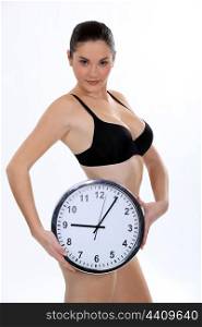 Woman in bra holding clock