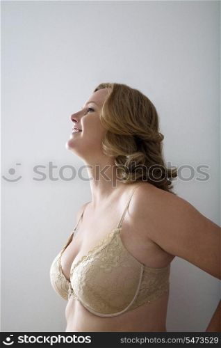 Woman in bra smiling against gray background