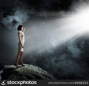 Woman in bright light. Young businesswoman blinded with light going from above