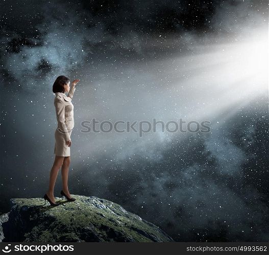 Woman in bright light. Young businesswoman blinded with light going from above