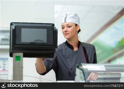 woman in butchers taking and order