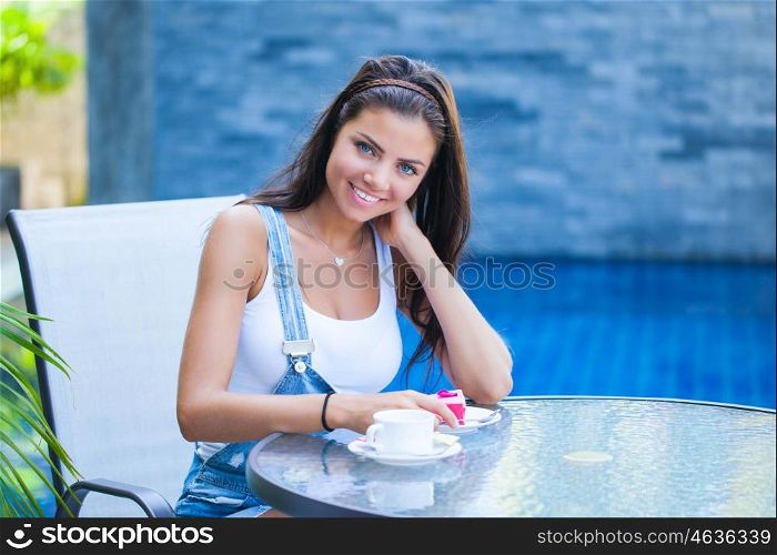 Woman in cafe. A young woman is having coffee and cake outside by the street
