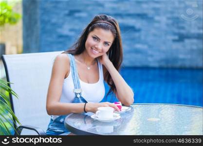 Woman in cafe. A young woman is having coffee and cake outside by the street