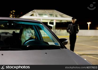 Woman in car and man in parking lot