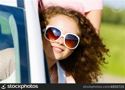 Woman in car. Young pretty woman leaning out of car window