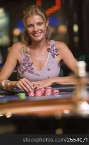 Woman in casino playing roulette smiling (selective focus)