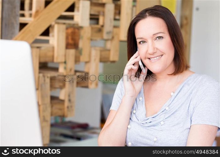 Woman in casual wear with his mobile in office