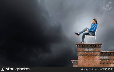 Woman in chair. Young woman in casual sitting on in chair on top of building