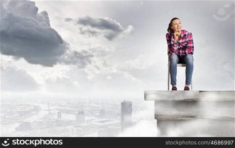 Woman in chair. Young woman in casual sitting on in chair on top of building