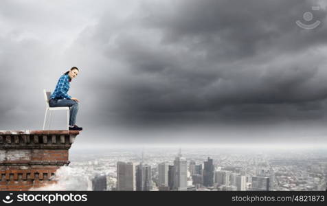 Woman in chair. Young woman in casual sitting on in chair on top of building