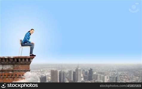 Woman in chair. Young woman in shirt sitting in chair on building roof
