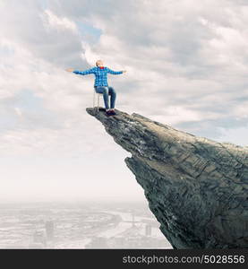 Woman in chair. Young woman in shirt sitting in chair on rock top