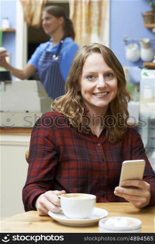 Woman In Coffee Shop Using Mobile Phone