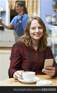 Woman In Coffee Shop Using Mobile Phone