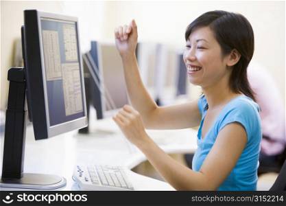 Woman in computer room cheering and smiling
