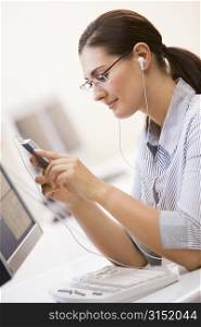 Woman in computer room listening to MP3 Player