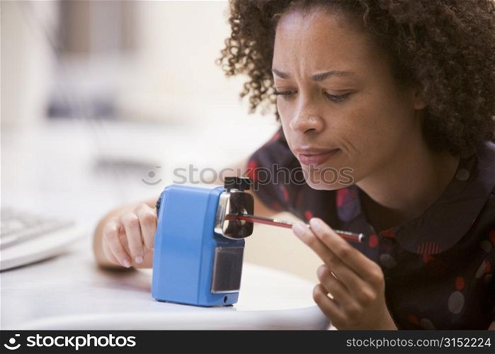 Woman in computer room using pencil sharpener