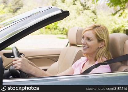 Woman in convertible car smiling