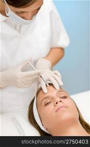 Woman in cosmetic medicine treatment getting botox injection, close-up portrait