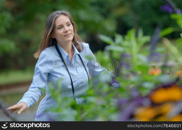 woman in countryside looking over fence