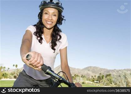 Woman in cycling helmet holds handlebars of mountainbike