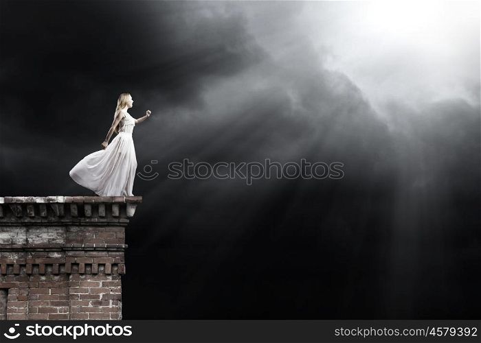 Woman in darkness. Young woman in in darkness reaching to sun light