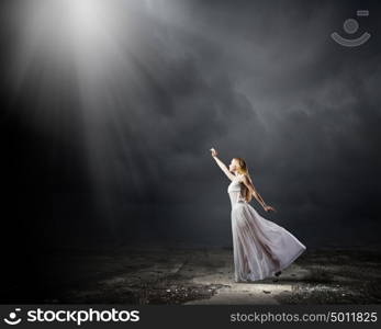 Woman in darkness. Young woman in in darkness reaching to sun light