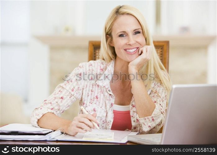 Woman in dining room with laptop frowning