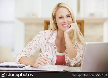 Woman in dining room with laptop frowning