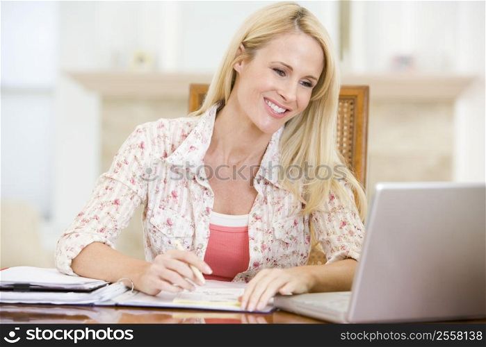 Woman in dining room with laptop smiling